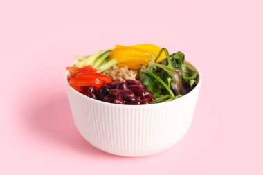 Pembe arka planda sağlıklı kinoa salatası, yakın plan.