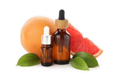 Bir şişe greyfurt kozmetik yağı ve beyaz arka planda meyveler