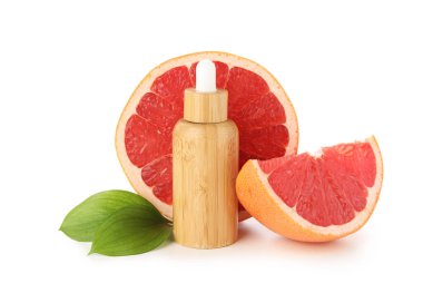 Beyaz arka planda bir şişe greyfurt kozmetik yağı ve meyve.