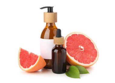 Beyaz arka planda greyfurt kozmetik ürünleri ve meyve şişeleri
