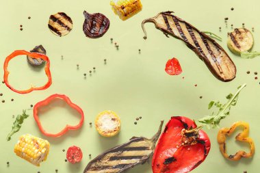 Yeşil arka planda uçuşan lezzetli ızgara sebzelerden yapılmış çerçeve