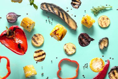 Turkuaz arka planda farklı lezzetli ızgara sebzeler uçuşuyor.