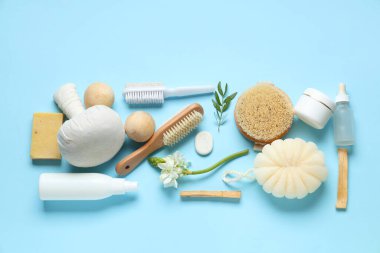 Ayak masajı için farklı banyo malzemeleri ve mavi arka planda çiçekler.