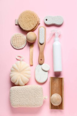 Pembe arka planda ayak masajı için farklı banyo malzemeleri.