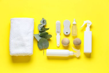 Ayak masajı için banyo malzemeleri ve sarı arka planda yeşil dal.