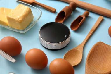 Modern mutfak zamanlayıcısına sahip kompozisyon, mavi arka planda malzemeler ve çatal bıçaklar, yakın plan