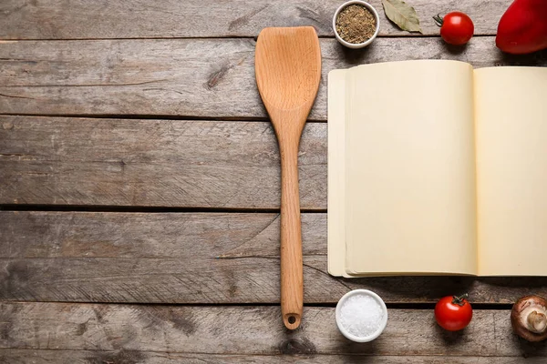 Boş tarif defteri, ahşap spatula ve ahşap arka planda malzemeler içeren kompozisyon