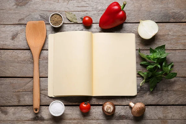 Boş tarif defteri, ahşap spatula ve ahşap arka planda malzemeler içeren kompozisyon