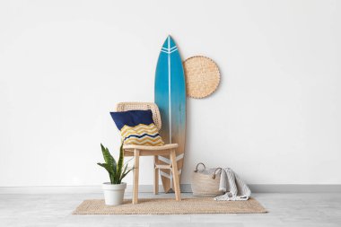 Sörf tahtası, ev bitkisi ve sandalyeli modern tarz bir oda.