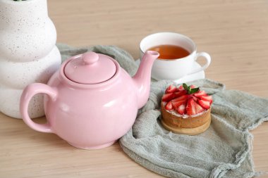 Pembe çaydanlık ve lezzetli kek mutfaktaki masada, yakın plan.