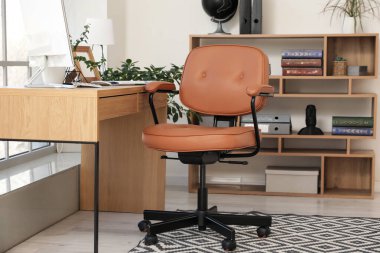 Çalışma odasının yanındaki kahverengi deri döner sandalye, yakın plan.