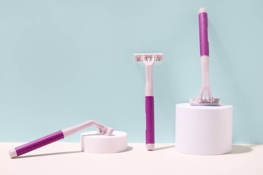 Alçı tezgahlı kompozisyon ve yeşil duvarın yanındaki masada tek kullanımlık tıraş bıçakları.