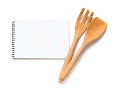 Beyaz arkaplanda spatula bulunan boş tarif kitabı