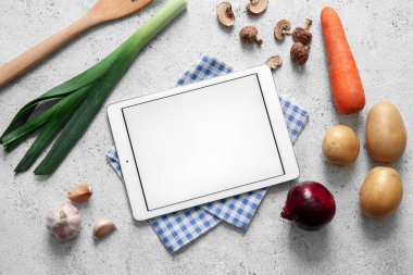 Beyaz grunge arka planında peçete, spatula ve malzeme içeren dijital tarif kitabı