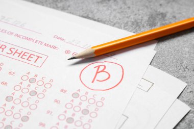 Gri grunge arkaplan sonuçlarıyla okul sınavının kalem ve cevap kağıtları formu, yakın plan