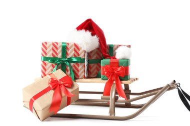 Sled with Christmas gifts and Santa hat isolated on white background