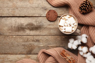 Bir fincan kakao, kurabiye, süveter ve tahta arka planda pamuk çiçekleri. Merhaba kış.