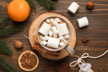 Tahta zemin üzerinde köknar dalları olan bir fincan kakao. Merhaba kış.