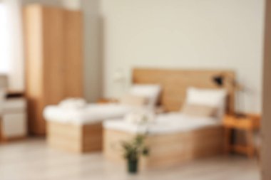 İki yataklı, masalı ve dolabı olan bir otel odası.