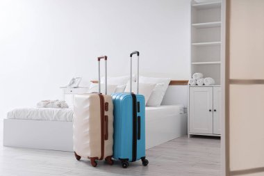 İçinde yatak, dolap ve bavullar olan bir otel odası.