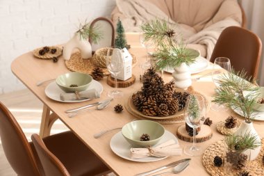 Odasında çam kozalakları ve dallar olan kış masası.