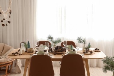 Odasında çam kozalakları ve dallar olan kış masası.