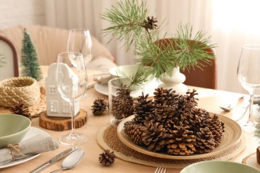 Odasında çam kozalakları ve dallar olan kış masası.