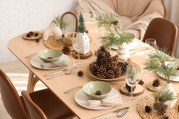 Odasında çam kozalakları ve dallar olan kış masası.