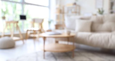 Kanepesi ve masası bulanık, modern aydınlık oturma odasının içi.