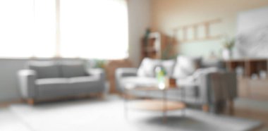 Oturma odasının bulanık manzarası, kanepeler ve masa.