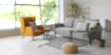 Bulanık oturma odası, gri kanepe, koltuk ve puf.