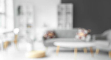 Gri kanepeli, masalı ve raf üniteli oturma odasının bulanık görüntüsü