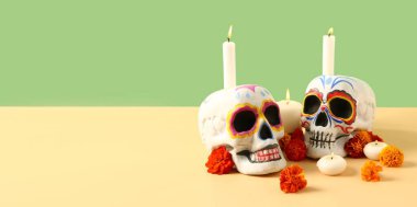 Boyalı kafatasları, kadife çiçekleri ve renkli arka planda mumlar ve metin için yer. El Dia de Muertos (Ölüler Günü))