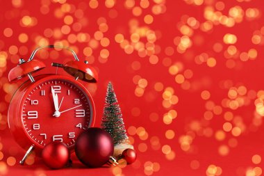 Kırmızı arkaplanda Noel dekoru ve metin için yeri olan alarm saati