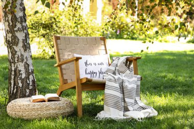 Battaniyeli, yastıklı ve parktaki, dışarıdaki kanepeli rahat hasır koltuk.