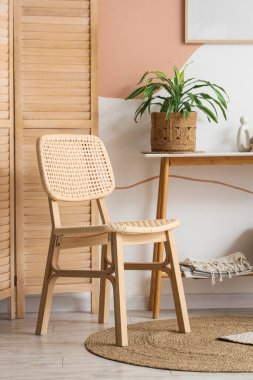 Hasır koltuklu, masa ve katlanan ekranlı odanın içi