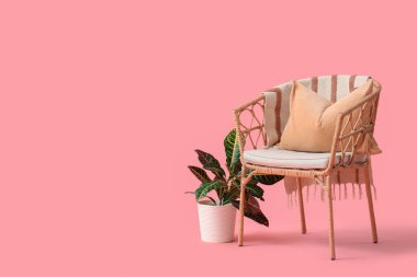 Pembe arka planı olan hasır bir koltuk.