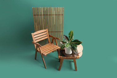 Masalı ahşap sandalye, puflar ve yeşil arka planda katlanır ekran