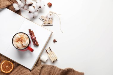 Bir fincan kakao, pamuk çiçekleri ve beyaz arka planda kazak olan bir kitap. Merhaba kış.