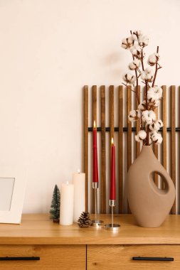 Noel ağacı ve pamuk çiçekleriyle yanan mumlar.