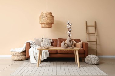 Oturma odasının içinde kanepe, merdiven ve yanan mumlar var.