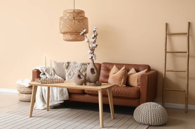 Oturma odasının içinde kanepe, merdiven ve yanan mumlar var.