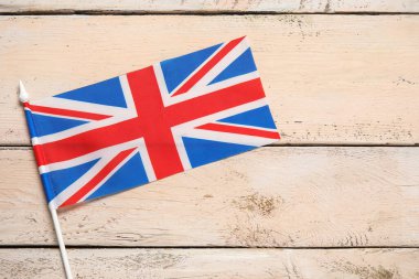 National flag of the United Kingdom on beige wooden background