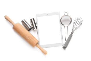 Beyaz arka planda mutfak gereçleri olan dijital tarif kitabı
