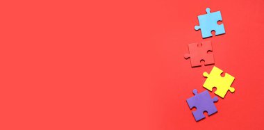 Kırmızı arkaplanda metin için alanı olan renkli yapboz parçaları