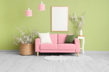 Pembe kanepe ve çiçeklerle modern oturma odasının içinde.