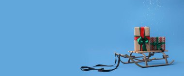 Hediye ile kızak ve mavi arkaplan üzerine düşen kar ile metin için boşluk