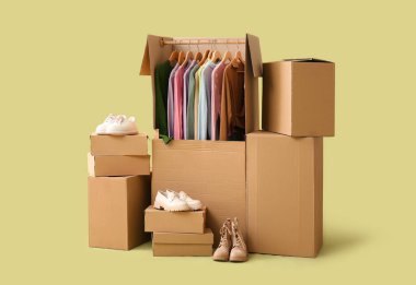 Giysileri ve ayakkabıları sarı arka planda olan dolaplar.