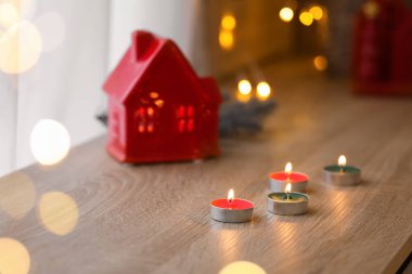 Noel için dekore edilmiş oturma odasındaki rafta mum yakmak, yakın plan.