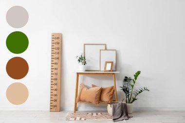 Odanın içinde ahşap stadyum ölçer, ev bitkileri ve masa var. Farklı renk desenleri